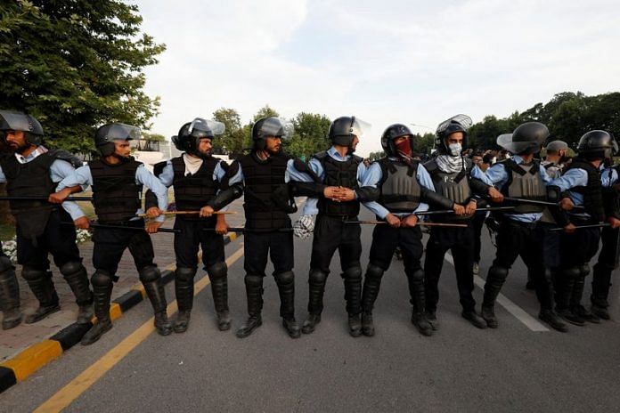 Police officers stand in a position to stop the supporters of Pakistan's former PM Imran Khan as he appeared before the Supreme Court in Islamabad, on 11 May 2023 | Reuters