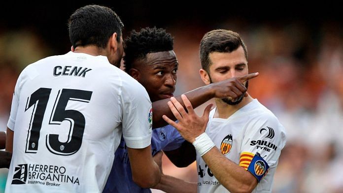 Real Madrid's Vinicius Junior gestures towards a fan as Valencia's Jose Gaya and Cenk Ozkacar attempt to restrain him | Reuters/Pablo Morano