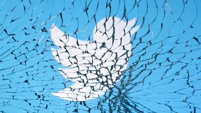 Twitter logo is seen through broken glass | Illustration by Dado Ruvic/Reuters