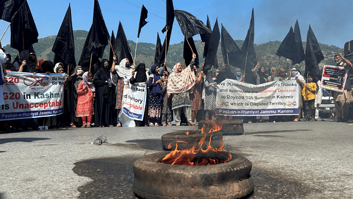 People carry black flags and set tyres ablaze to condemn India's decision to host the G20 Tourism Working Group meeting in Srinagar, during a protest in Muzaffarabad, Pakistan-administrated Kashmir, May 22, 2023. REUTERS/Stringer