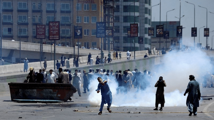 Supporters of Pakistan's former PM Imran Khan throw stones at police during a protest against Khan's arrest, in Peshawar, Pakistan, | Reuters/Fayaz Aziz