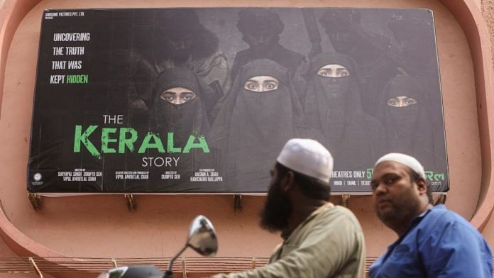 People ride past a poster of a Hindi movie titled 'The Kerala Story', outside a cinema in Mumbai | Reuters