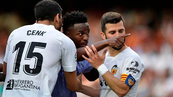 Real Madrid's Vinicius Junior gestures towards a fan as Valencia's Jose Gaya and Cenk Ozkacar attempt to restrain him | Reuters/Pablo Morano