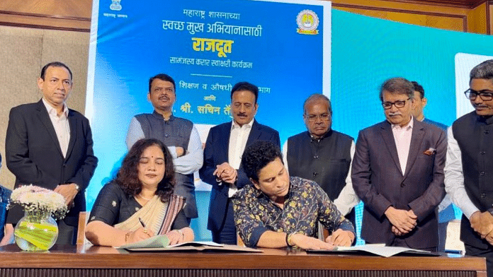 Sachin Tendulkar signs a document to become Smile Ambassador of Maharashtra. Deputy Chief Minister Devendra Fadnavis (second from left) is seen in the background | Twitter | @Dev_Fadnavis