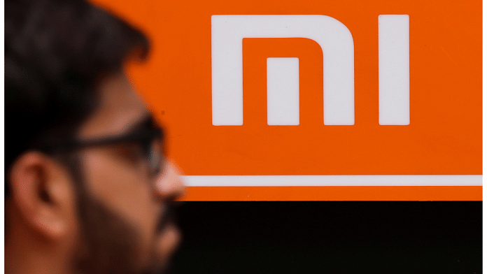 A man walks past a logo of Xiaomi, a Chinese manufacturer of consumer electronics, outside a shop in Mumbai | Reuters/Francis Mascarenhas