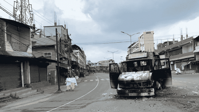 People passing by a vehicle that was set alight in Imphal | Karishma Hasnat | ThePrint