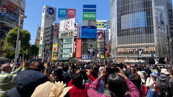 Pedestrians and tourists wait to cross the road at one of the world's busiest pedestrian intersection — the Shibuya scramble crossing — outside the Shibuya station, Tokyo. | Keshav Padmanabhan | ThePrint
