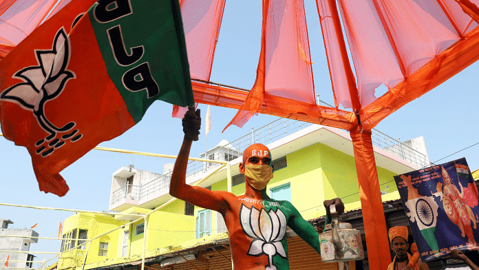 A man paints himself with BJP's lotus sign and holds tea kettle in support of PM Modi in Ayodhya | ANI file photo