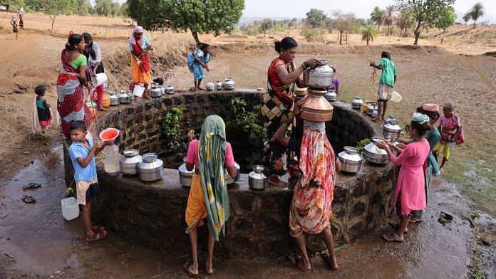 Women gather around a well to draw water from it in Telamwadi, near Mumbai | Reuters