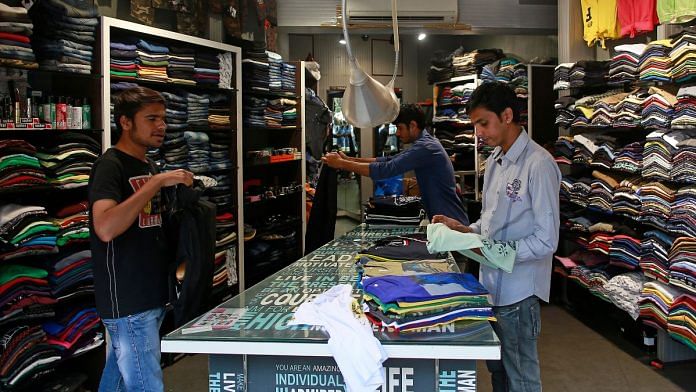 Salesmen fold shirts inside a clothes store at a market in Mumbai | Reuters file photo