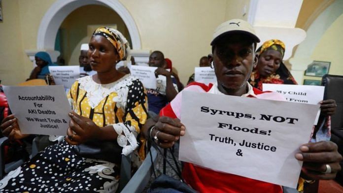 Grieving parents hold up signs during a news conference, calling for justice for the deaths of children linked to contaminated cough syrups, in Serekunda, Gambia | Reuters file photo
