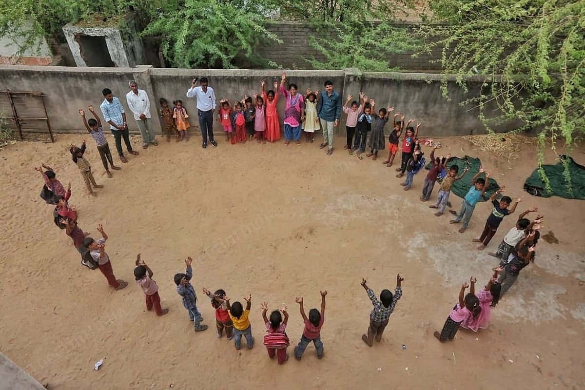 Children of Vadiya School wave in the air. | Photo: Praveen Jain | ThePrint