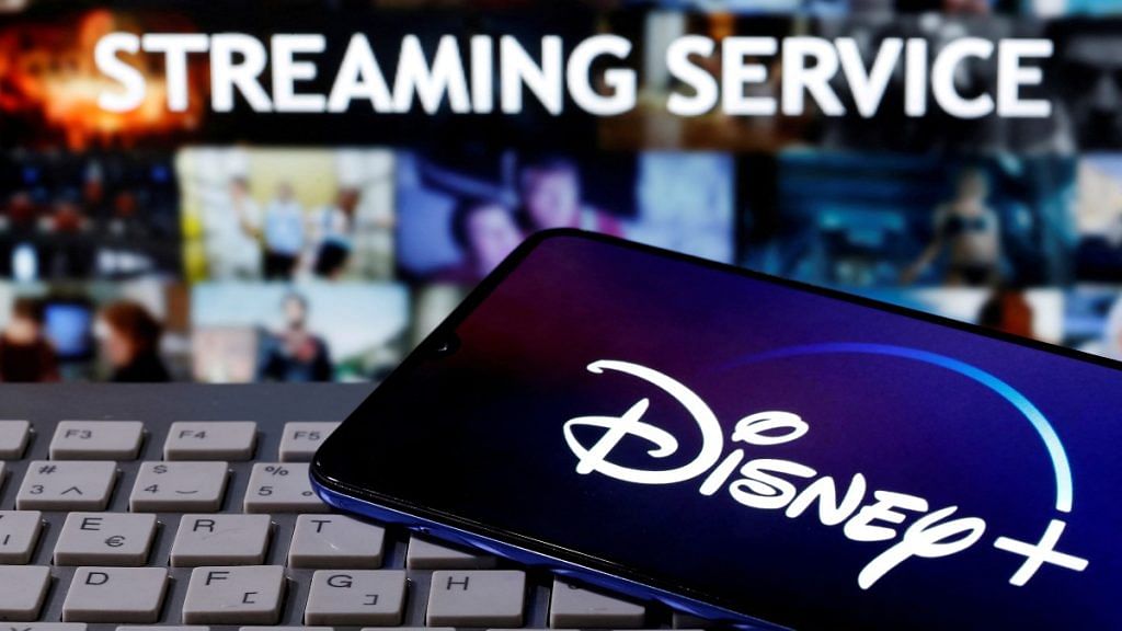 A smartphone with displayed "Disney" logo is seen on the keyboard in front of displayed "Streaming service" words in this illustration | Reuters