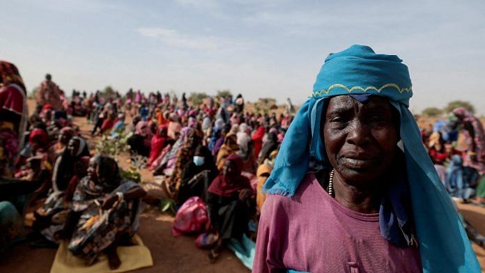 Halime Adam Moussa, a Sudanese refugee who is seeking refuge in Chad for a second time, waits with other refugees to receive a food portion from World Food Programme (WFP), near the border between Sudan and Chad in Koufroun | Reuters