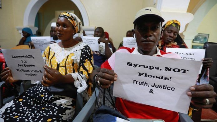 Grieving parents hold up signs during a news conference, calling for justice for the deaths of children linked to contaminated cough syrups, in Serekunda, Gambia, November 4, 2022. In October 2022, the deaths of more than 70 Gambian children from Acute Kidney Injury were linked by global health officials to cough syrups made in India and contaminated with ethylene glycol (EG) and diethylene glycol (DEG) | Reuters