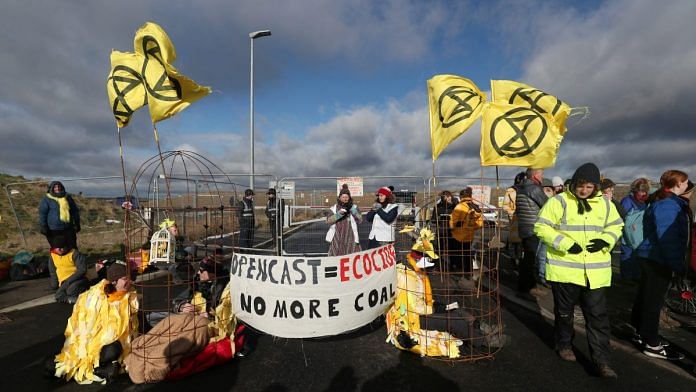 Extinction Rebellion demonstrators sit in structures representing 