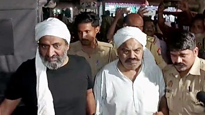 Police personnel escort Mafia-turned-politician Atiq Ahmed for a medical examination, in Prayagraj on Thursday. Atiq's brother Khalid Azim alias Ashraf also seen | ANI