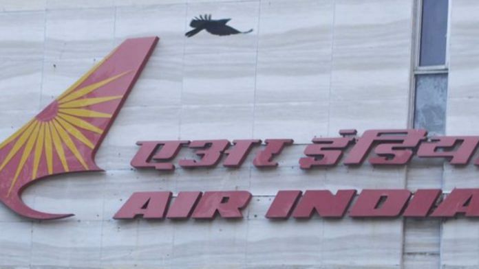 A bird flies over a logo of Air India airlines at the corporate headquarters in Mumbai | Reuters