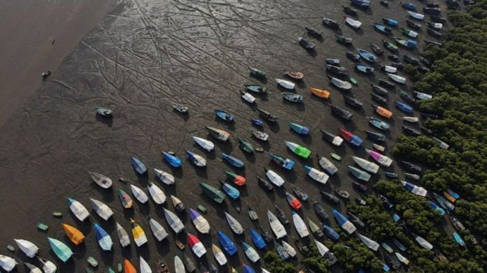 An aerial view of fishing boats covered with tarpaulin sheets parked on the shore, before the start of the monsoon season, on the outskirts of Mumbai, India | Image via REUTERS