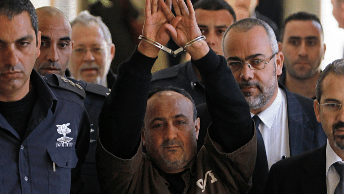 An Israeli prison guard escorts jailed Palestinian leader Marwan Barghouti to a deliberation at the Jerusalem Magistrate's Court on January 25, 2012 [File: Reuters/Baz Ratner]