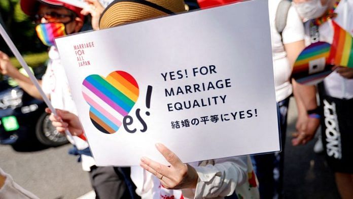 A participant holds a sign as they march during the Tokyo Rainbow Pride parade, celebrating advances in LGBTQ rights and calling for marriage equality, in Tokyo | File Photo: Reuters