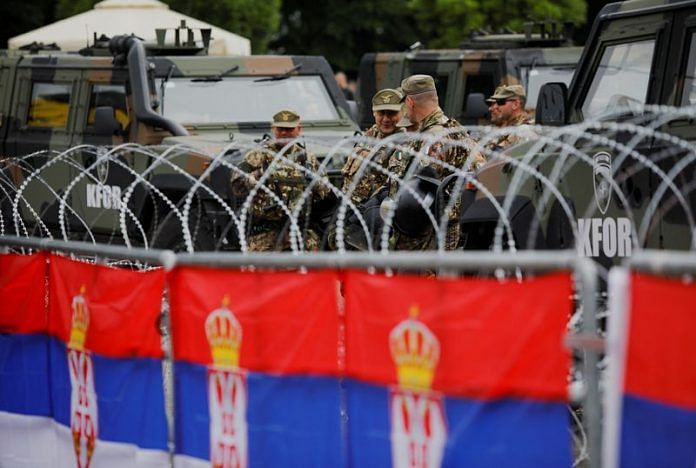 Italian members of the NATO-led Kosovo Force (KFOR) stand guard behind wire fencing, in Leposavic, Kosovo, on 1 June 2023 | Reuters/Ognen Teofilovski