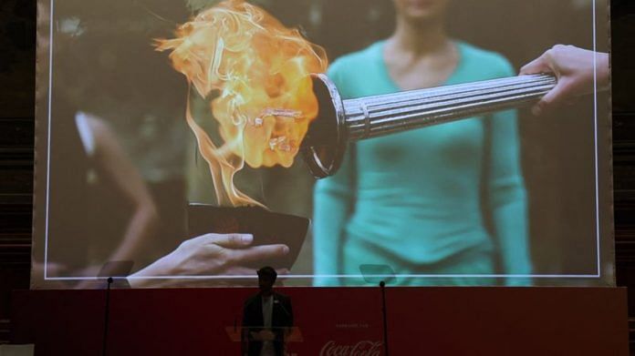 A screen displays an image of the Olympic flame being passed on during the presentation | Reuters/Stephanie Lecocq