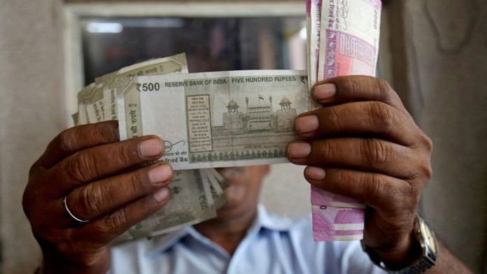 A cashier checks Indian rupee notes inside a room at a fuel station in Ahmedabad | Reuters/Amit Dave