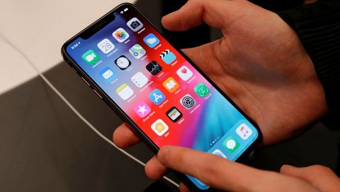 A customer tests a smartphone during the launch of the new iPhone XS and XS Max sales at 