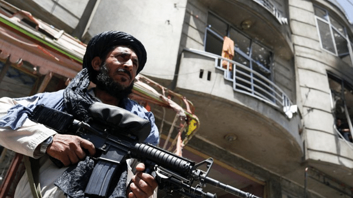 A Taliban fighter stands guard at the site where an explosive-laden vehicle detonated amidst an attack on a Sikh Temple in Kabul, Afghanistan | File photo via Reuters