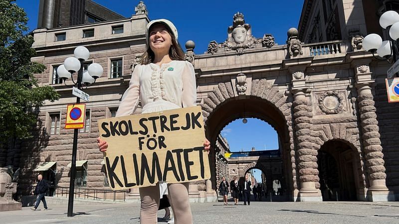 Greta Thunberg stands with a sign that reads, "School Strike for climate", outside the Swedish Parliament on the day of her weekly protest in Stockholm, Sweden, on 9 June, 2023 | Reuters