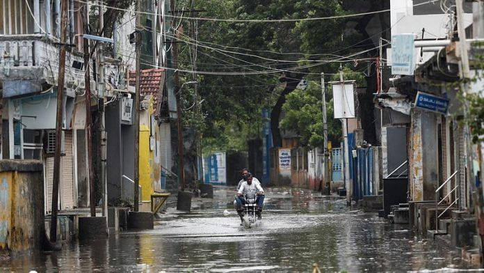 A man rides a motorcycle through a waterlogged street in Mandvi before the arrival of cyclone Biparjoy in the western state of Gujarat on 15 June, 2023 | Reuters