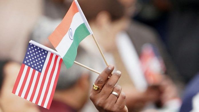 An attendee holds US and India's flags as they gather to watch PM Narendra Modi for a State Visit at the White House in Washington | Reuters