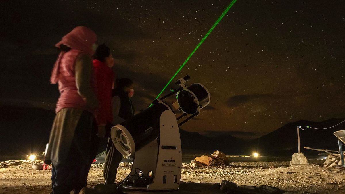 Local women help set up the telescope at an Astrostays location | by special arrangement