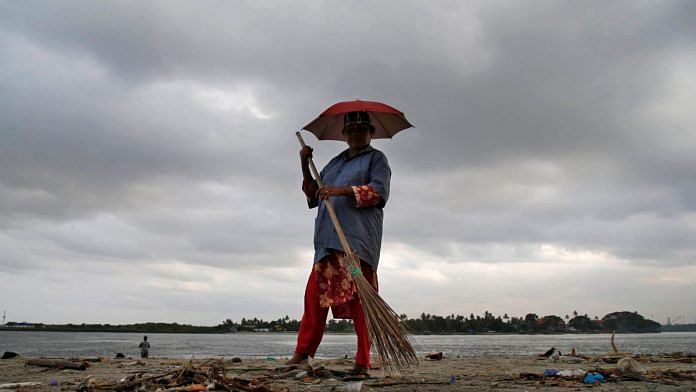 A worker cleans a beach, against the backdrop of pre-monsoon clouds, at Fort Kochi beach in Kochi | File Photo: Reuters