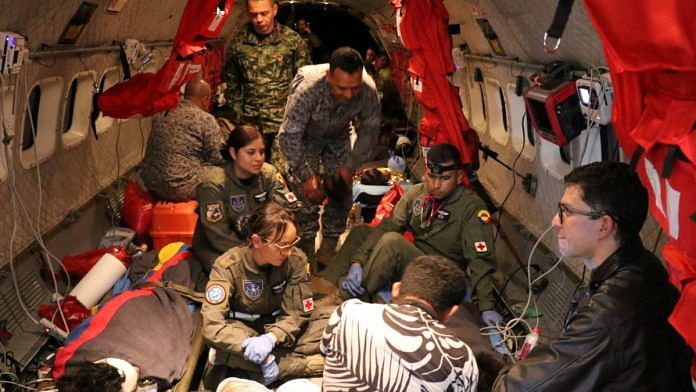 Soldiers of the Colombian Air Force and employees of the Colombian Family Welfare Institute give medical attention inside a plane to the surviving children | Colombian Air Force/Handout via Reuters