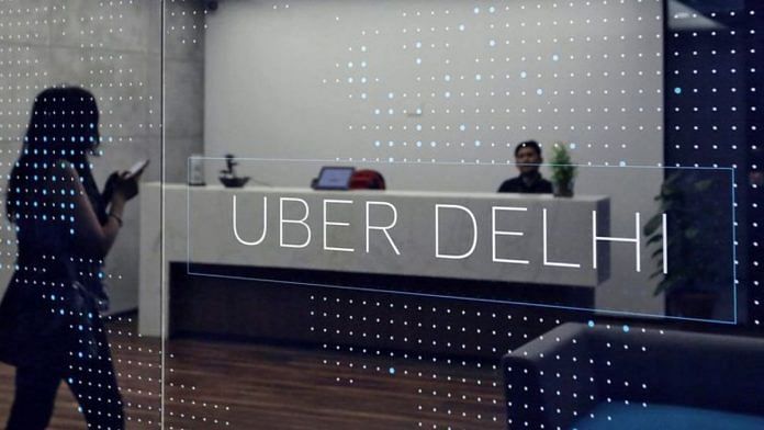 An employee walks inside the office of ride-hailing service Uber in Gurugram/File Photo: Reuters