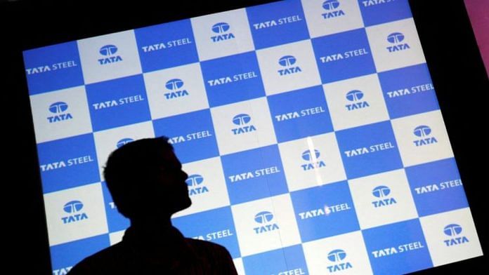 A man walks past a screen displaying the Tata Steel logo before the start of a news conference in Mumbai | Reuters