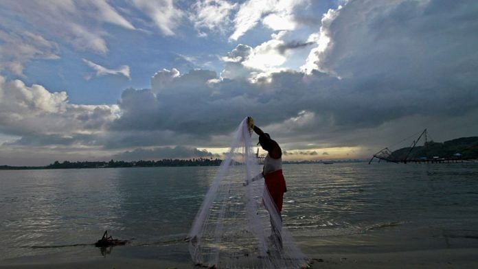 A fisherman arranges his fishing net at a beach against the backdrop of pre-monsoon clouds in the southern Indian city of Kochi | Reuters/Sivaram V./File Photo