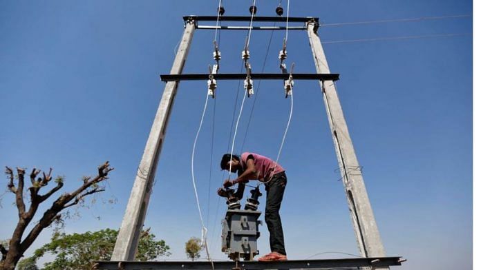 A man installs an electric transformer outside a wheat field on the outskirts of Ahmedabad | Reuters file photo