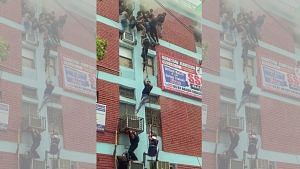 People escape using wires as a fire breaks out in a building located in Delhi's Mukherjee Nagar, on Thursday | ANI