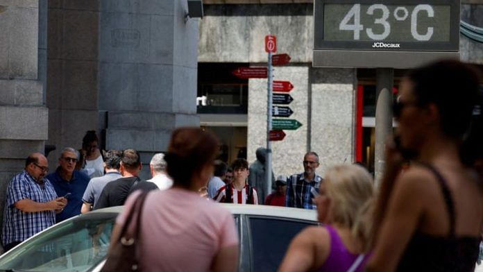 People walk near a sign indicating 43 degrees Celsius (109 F) as near record temperatures continue to affect the country, in Bilbao, Spain | Reuters