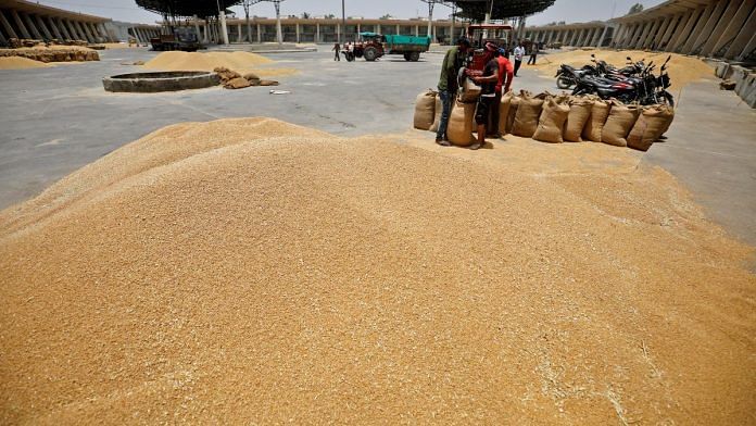 Workers fill sacks with wheat at the market yard of the Agriculture Product Marketing Committee (APMC) on the outskirts of Ahmedabad, India | Reuters/Amit Dave/File Photo