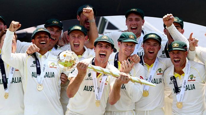 Australia's Pat Cummins celebrates with the ICC Test Mace on the podium along with teammates after winning the World Test Championship final | Action Images via Reuters/Paul Childs