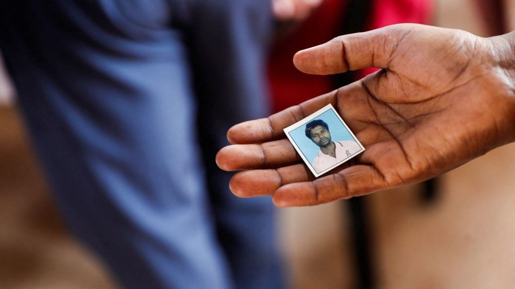 Jenima Mondal holds a photograph of her son Mamjur Ali Mondal after receiving his body from the mortuary after he was killed in a multiple train collision in Balasore, outside a hospital in Bhubaneswar in the eastern state of Odisha | Reuters