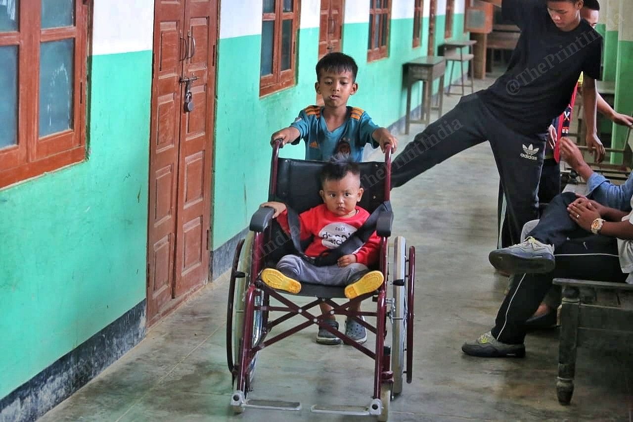 A kid pulls another in a wheelchair inside the shelter Photo: Praveen Jain | ThePrint