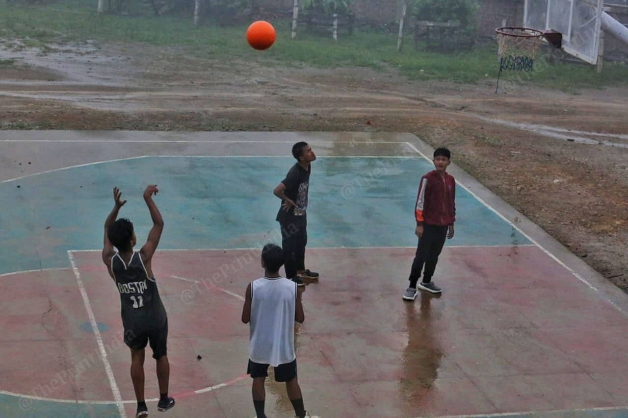While the children play in the corridors, youth play basketball in the school ground Photo: Praveen Jain | ThePrint