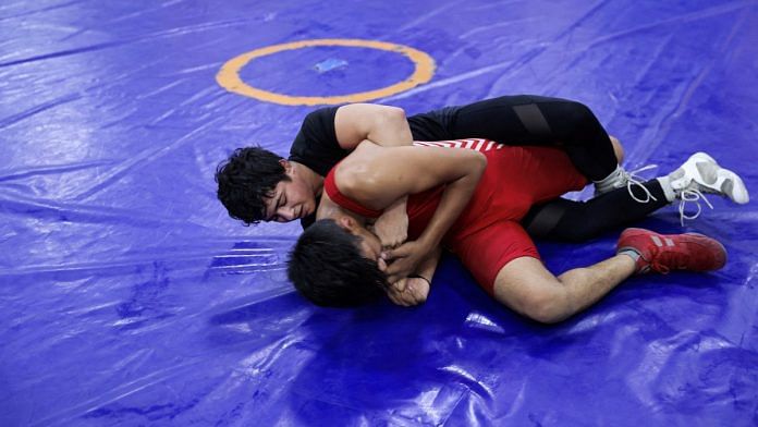 Simran Ahlawat, a female wrestler, practices wrestling with a male wrestler at an akhara in New Delhi | Reuters