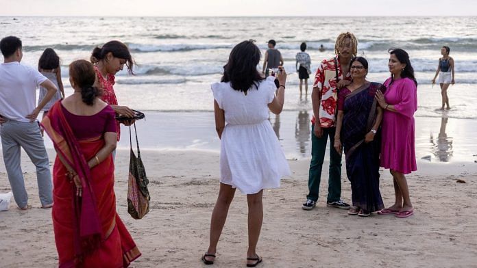 Members of the Shivkumar-Manjunatha family from India walk and take pictures during their first time familiy holiday trip to Thailand at Patong beach in the island of Phuket, Thailand | Reuters