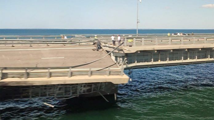 A view through a train window shows the section of a road split and sloping to one side following an alleged attack on the Crimea Bridge, that connects the Russian mainland with the Crimean peninsula across the Kerch Strait, in this still image from video taken on 17 July | Reuters